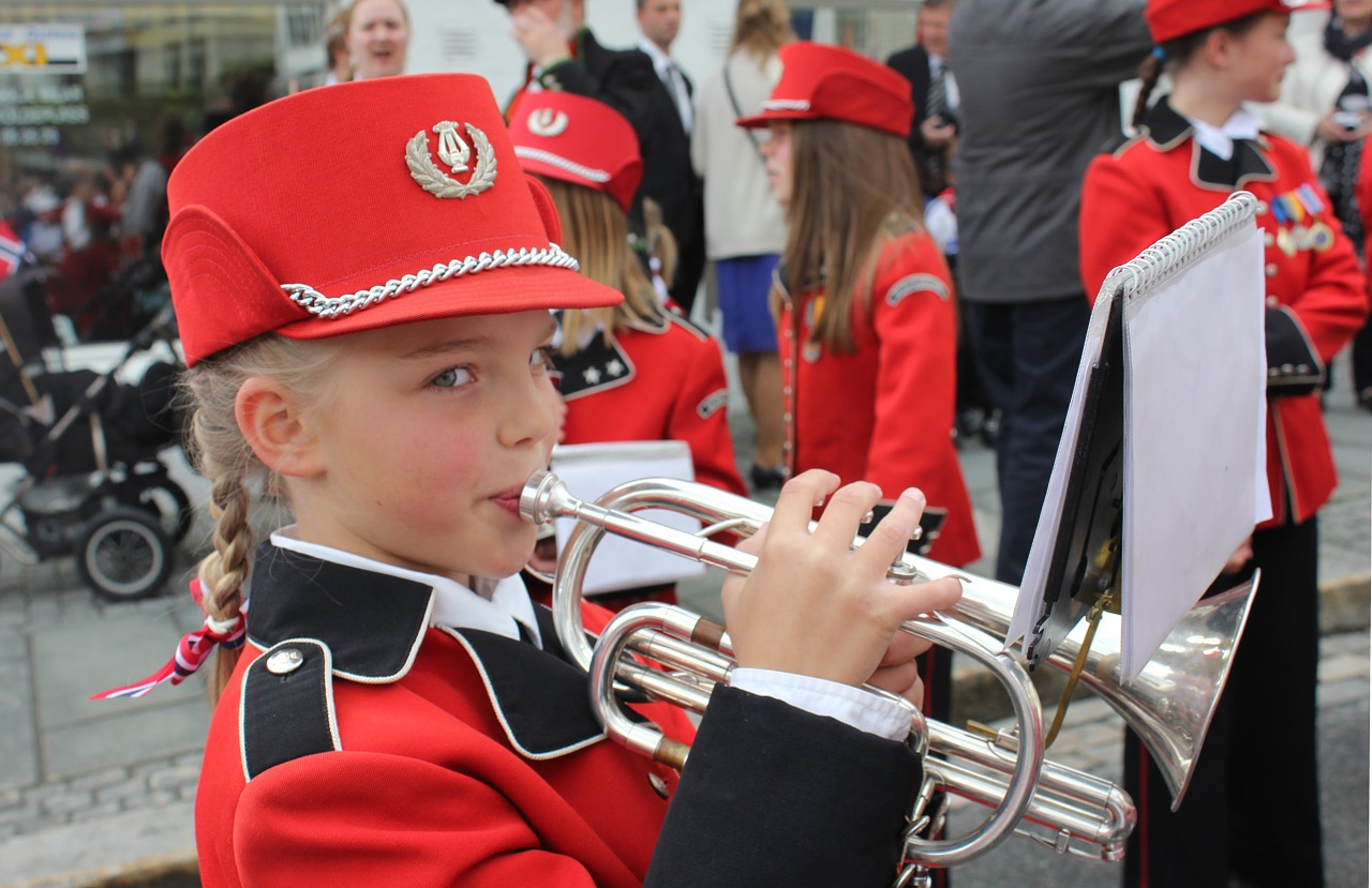 Girl with a band uniform playing the trumpet.